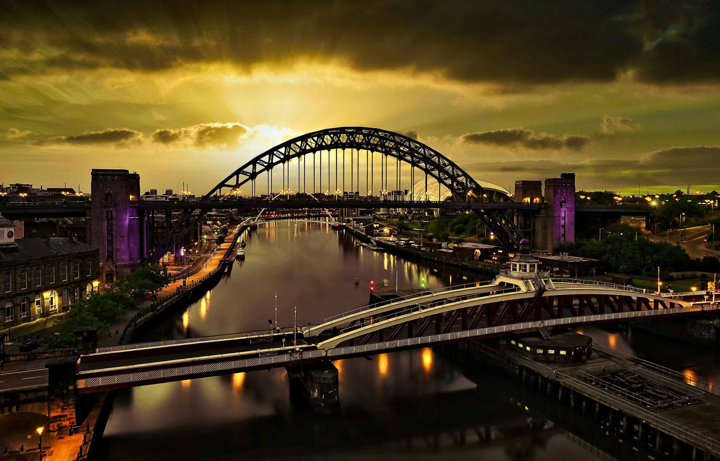 A captivating sunset view of the Tyne Bridge in Newcastle with vibrant reflections on the river.
