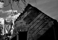 Grayscale Photo of a Concrete Shabby Building Near a Hanging Textile