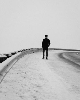 一个独来独往的人走在蒙特利尔白雪皑皑的街道上，身影被黑白相间的画面定格