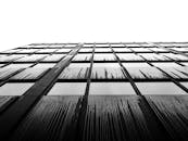 黑白雨纹映衬下，现代玻璃建筑呈现戏剧性的低角度视图