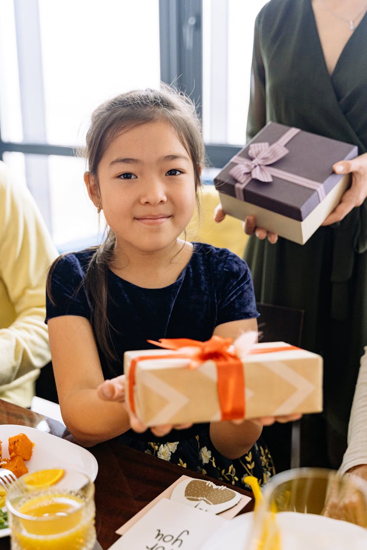 A Girl In Blue Velvet Top Handing Over A Present