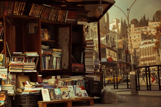 A quaint outdoor bookstall on the streets of Amman offers a variety of books in an urban setting.