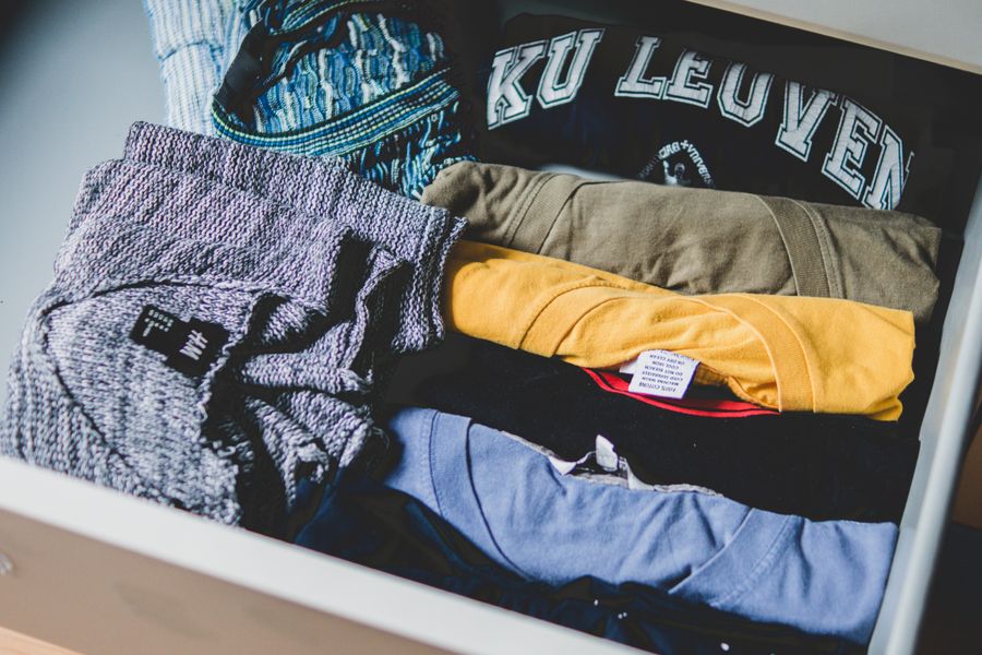 A neat arrangement of clothes and T-shirts in a drawer, showcasing casual wear.