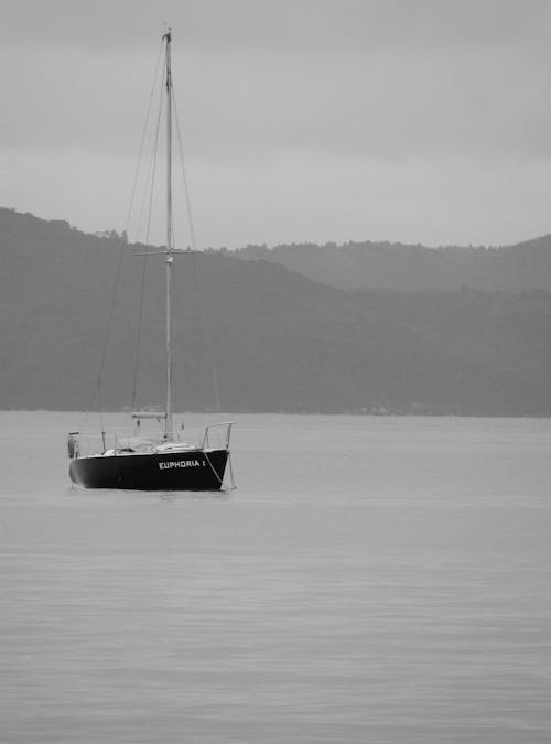 Grayscale Photo of Boat on Body of Water 