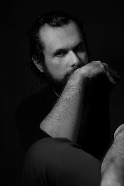 Free Artistic black and white portrait of a bearded man with a serious expression and thoughtful pose. Stock Photo
