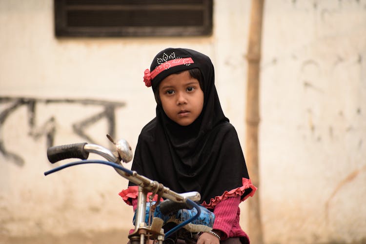 Girl In Black Hijab Riding Bicycle