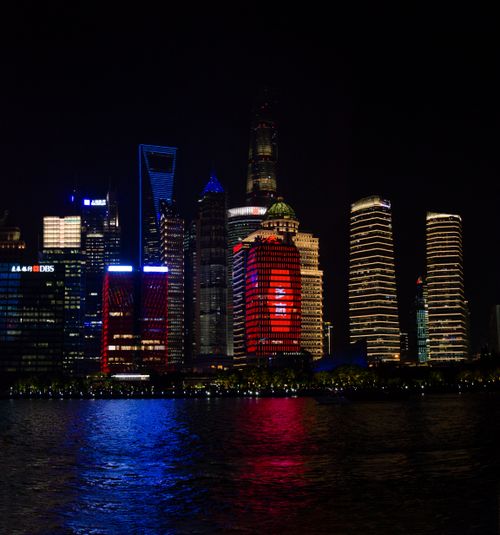 Free Stunning view of Shanghai's illuminated skyline reflecting on the Huangpu River at night. Stock Photo