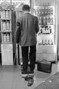 Faceless barefoot man standing on scale in store