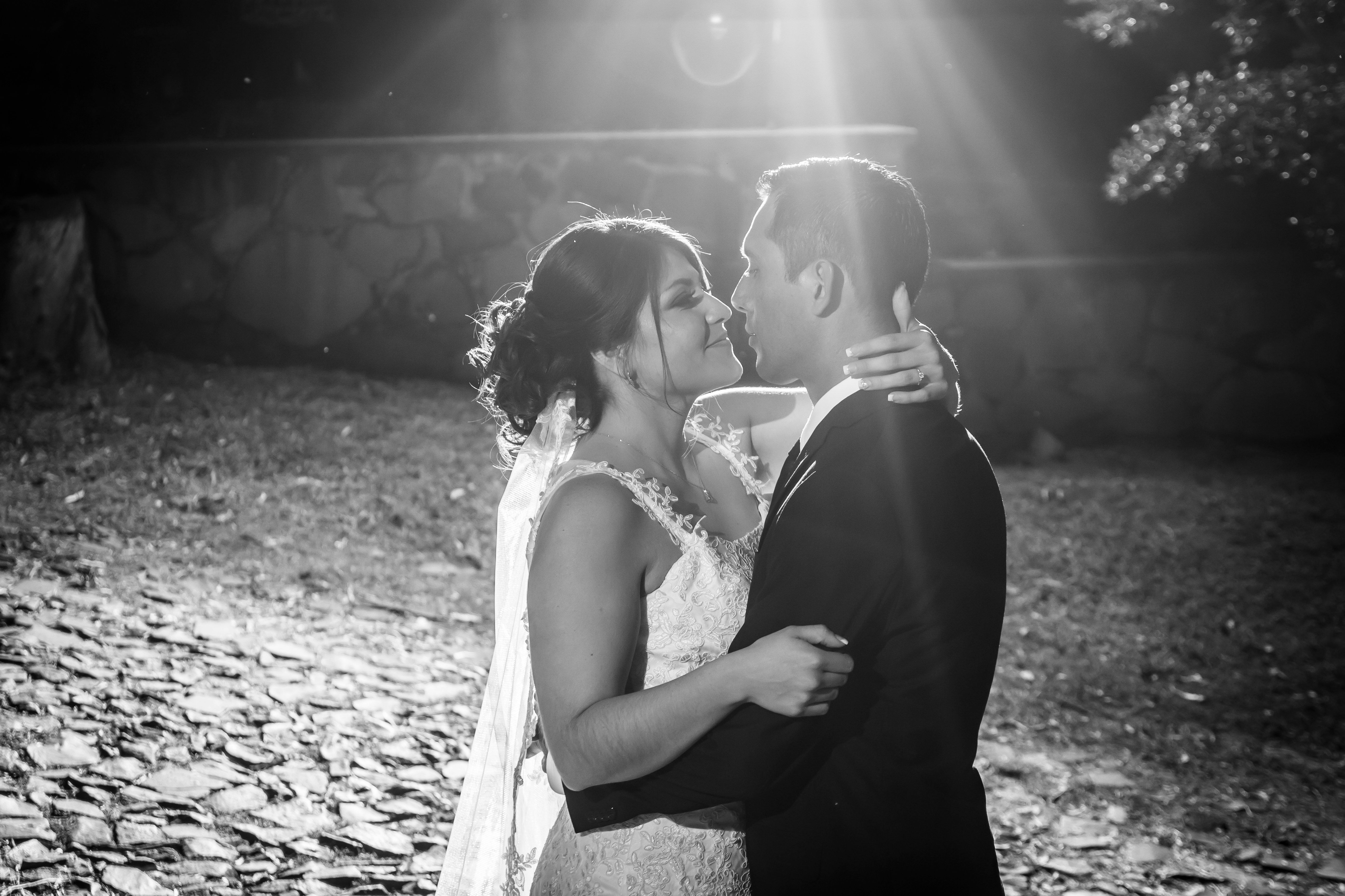 A couple shares an intimate embrace in a romantic black and white wedding photograph.