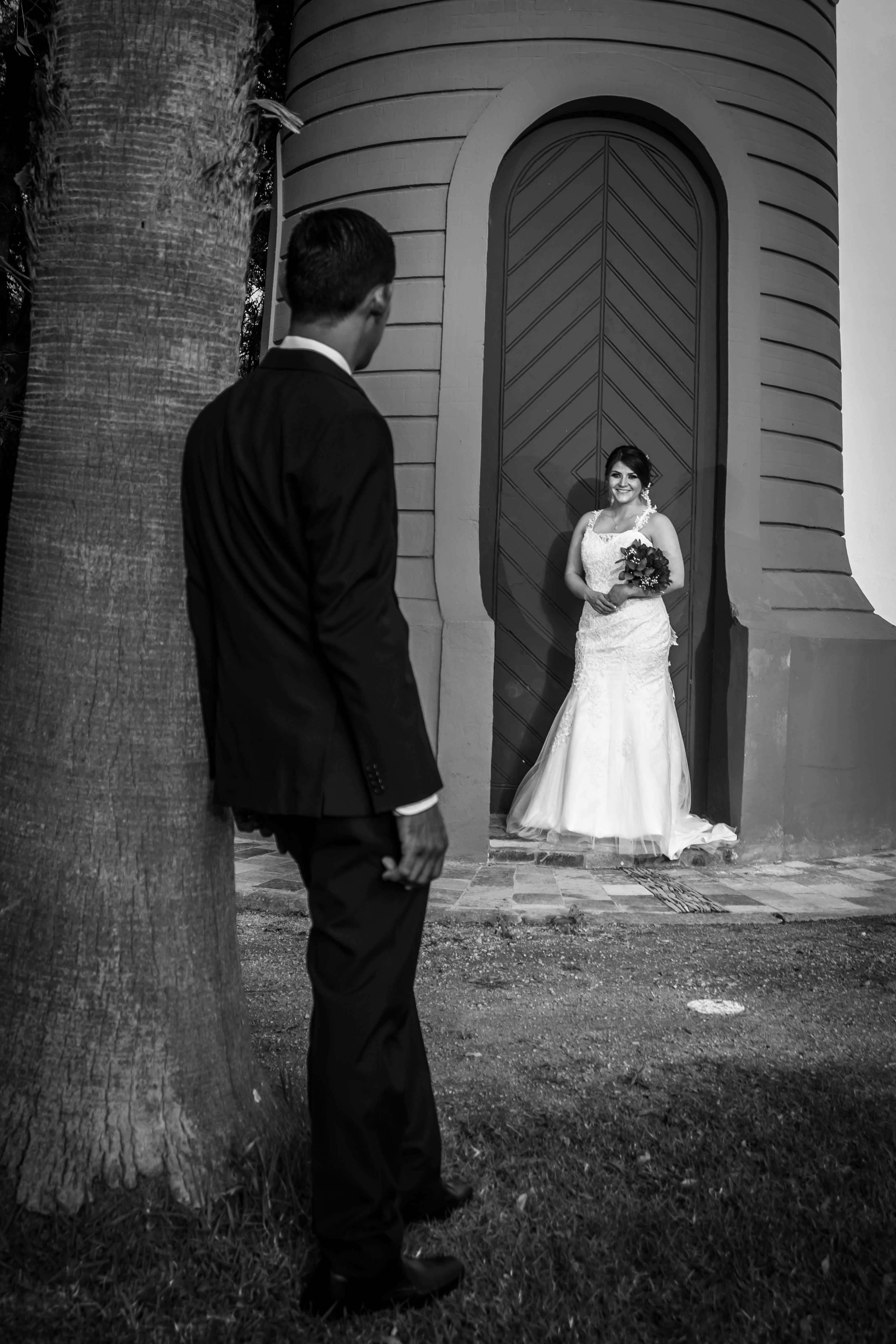 Black and white photo of a bride and groom in a romantic outdoor setting.