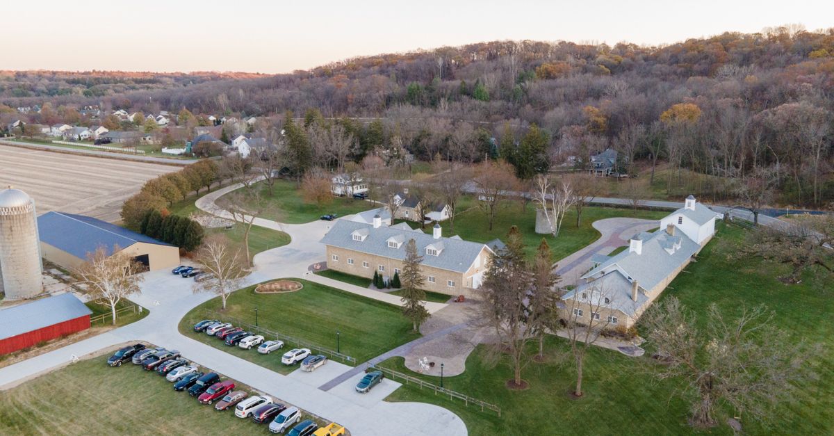 Aerial view of a countryside estate with parked cars and outbuildings in Rochester, MN.
