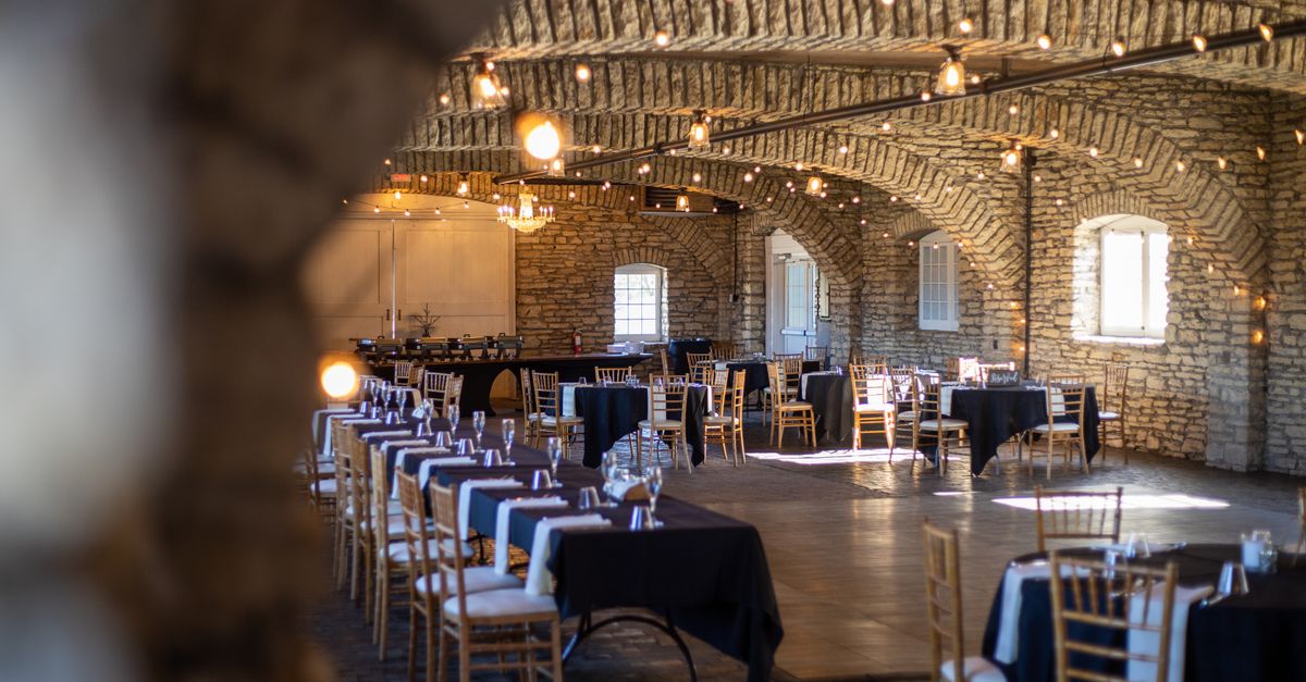 Beautiful rustic venue with wooden chairs, stone walls and natural lighting.