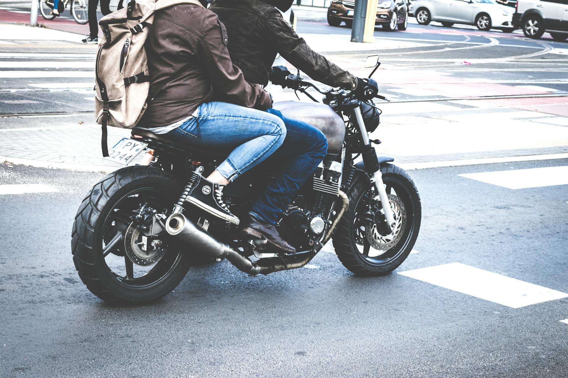 A couple riding a vintage motorcycle through city streets, showcasing urban exploration and freedom.