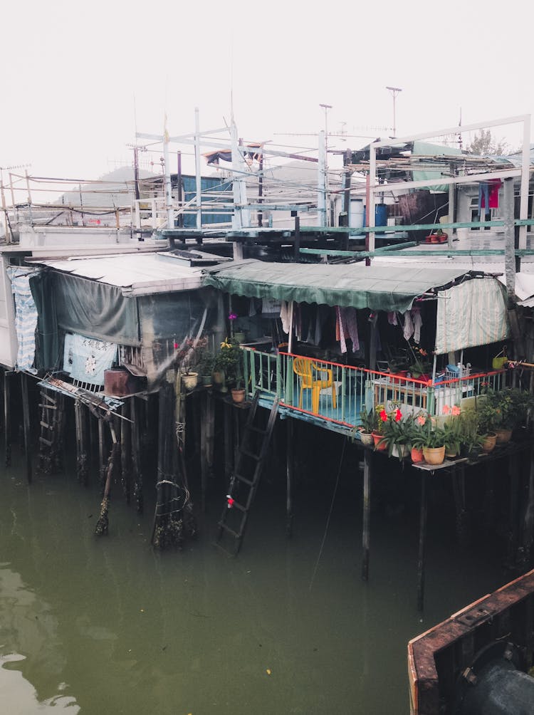 Wooden Houses On Pillars On Water In Poor Village