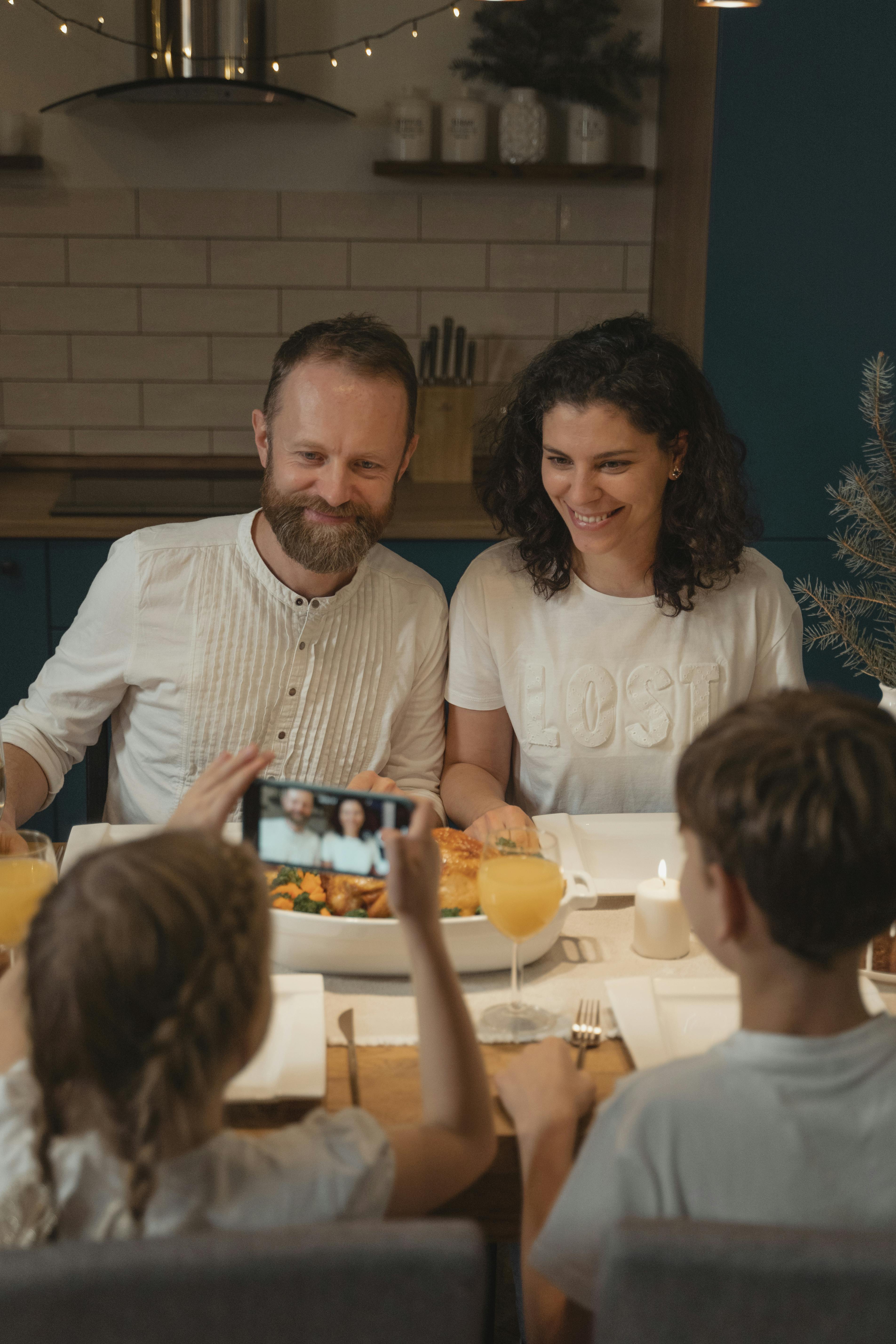 Family taking a photo during a cozy dinner, embracing holiday cheer and togetherness.