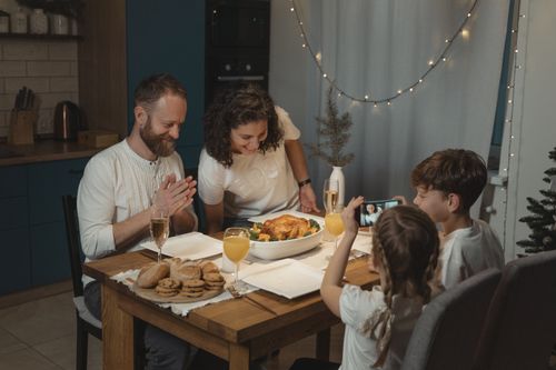 Free A joyful family sharing a festive holiday dinner at home, capturing memories with joy and togetherness. Stock Photo