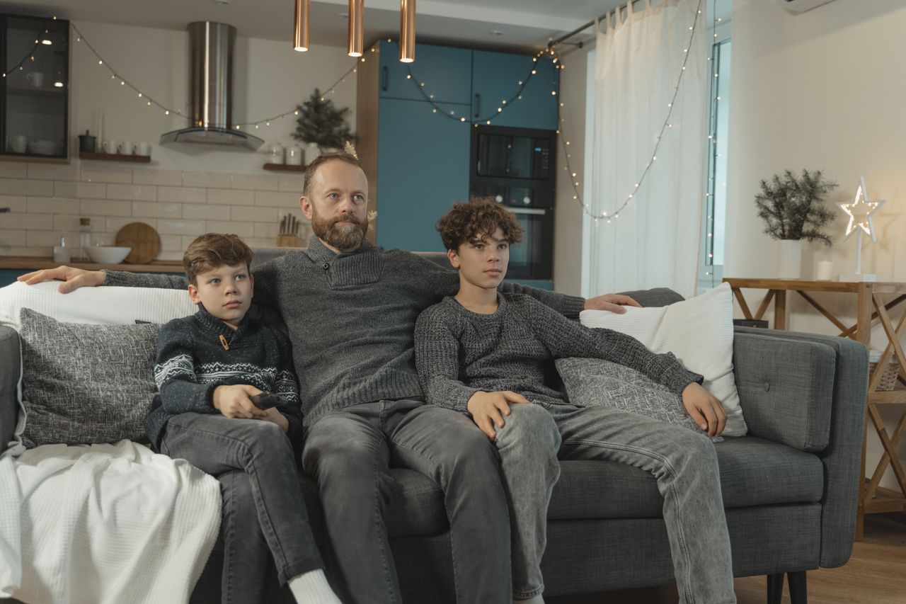 Turkish Channels Belgium — VRT, RTBF and Turkish channels in one app, no second box. Father and children watching television together on a sofa