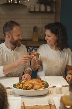 A joyful couple toasting over a festive Christmas dinner indoors with roasted turkey.