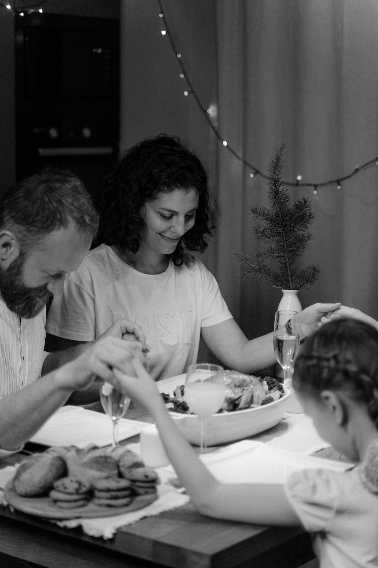 A Family Holding Hands For A Dinner Prayer