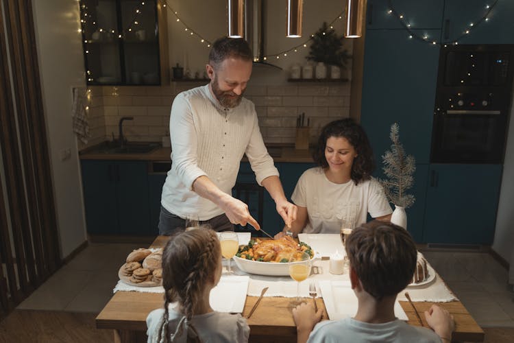 A Father Cutting The Roasted Turkey