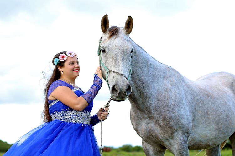 A Woman In A Blue Gown Beside A Horse