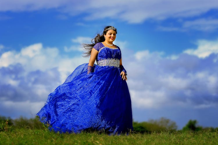 A Woman Wearing A Blue Gown And Tiara