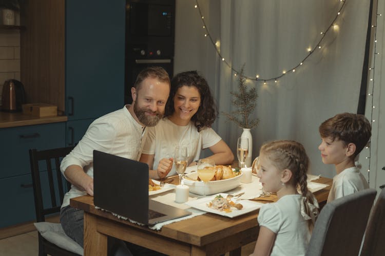 A Family Having Christmas Dinner While On Video Call