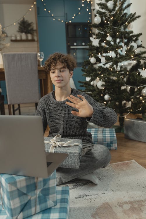 A Boy in a Video Call Holding a Christmas Present