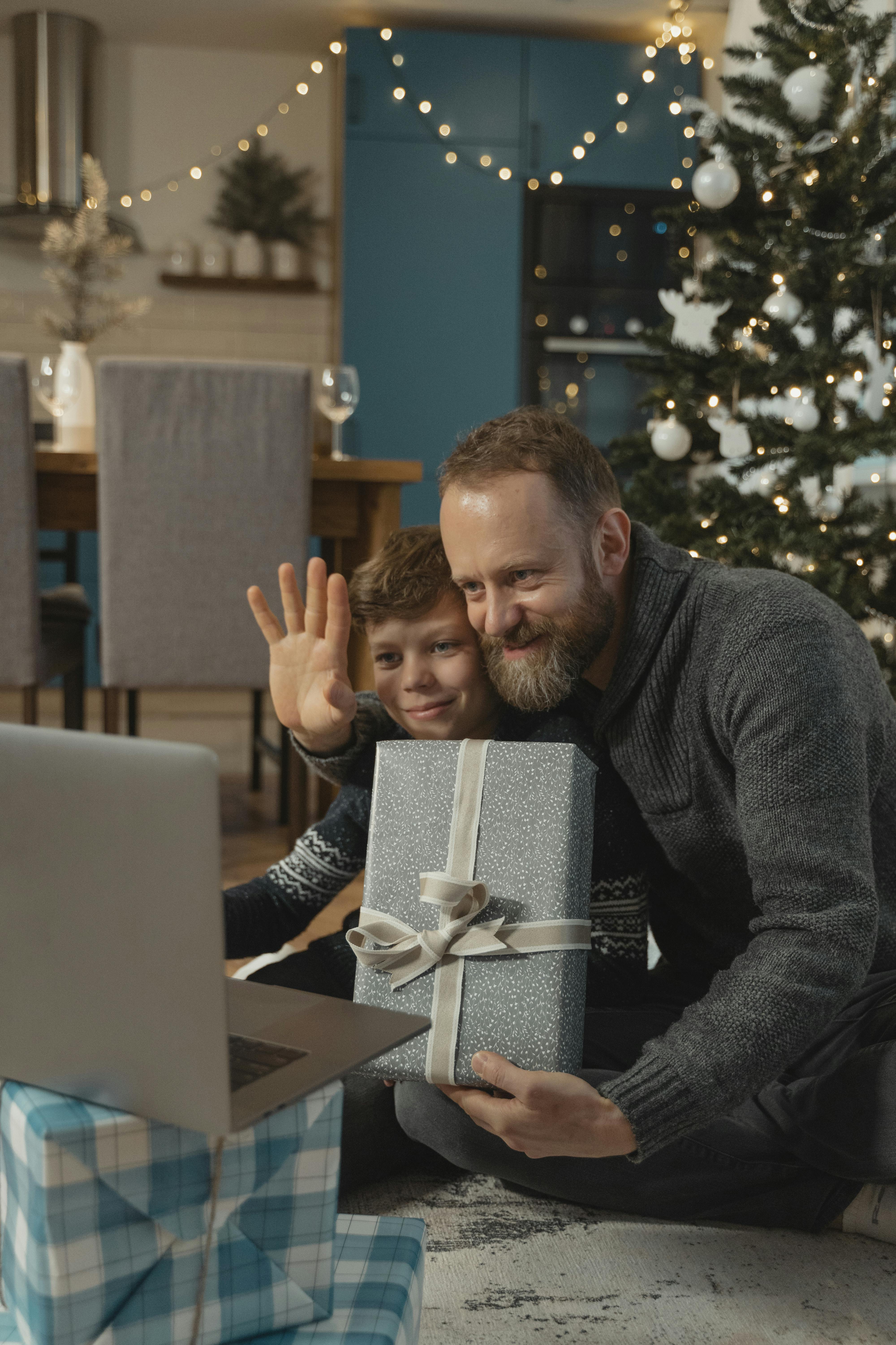 a man and a boy greeting christmas via video call