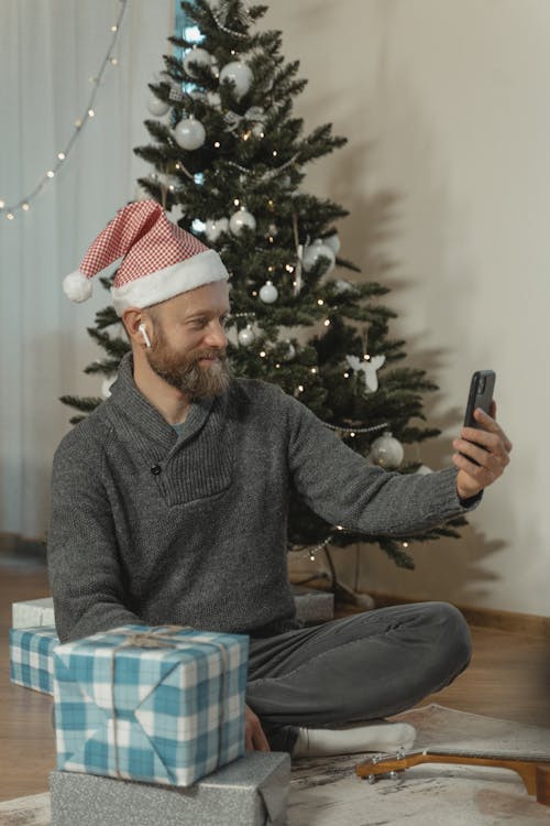 Free A Man in Gray Sweater Holding a Smartphone Stock Photo