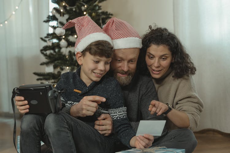 A Family Looking At An Instant Photo