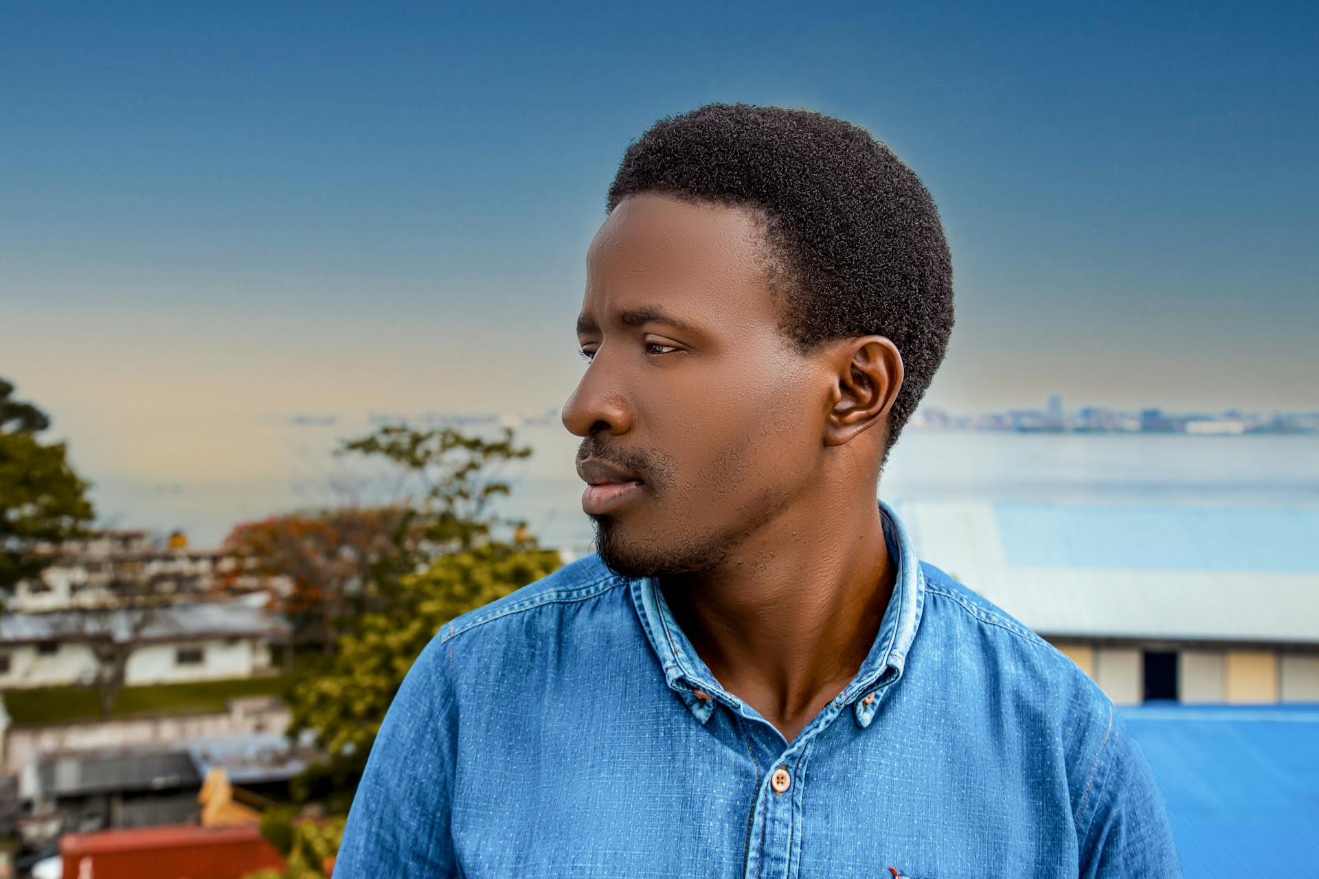 Side profile of a man outdoors in Brazzaville, showcasing serene expression against an urban backdrop.
