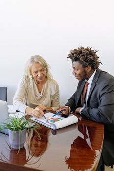 Two professionals discussing a colorful business graph during a meeting.