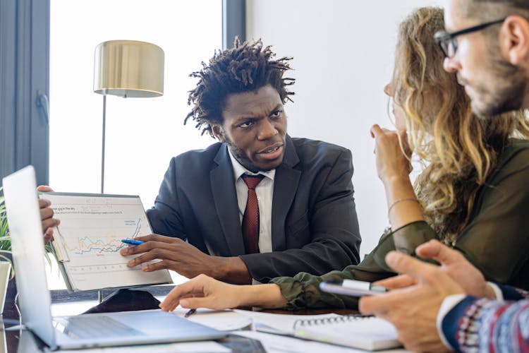 An Man In A Business Suit Talking To Clients