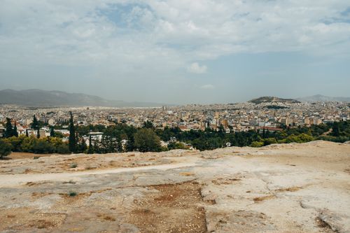 Free Panoramic view of Athens cityscape and rocky landscape under a cloudy summer sky. Stock Photo