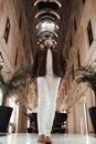 Faceless stylish man looking up in grand mansion hallway