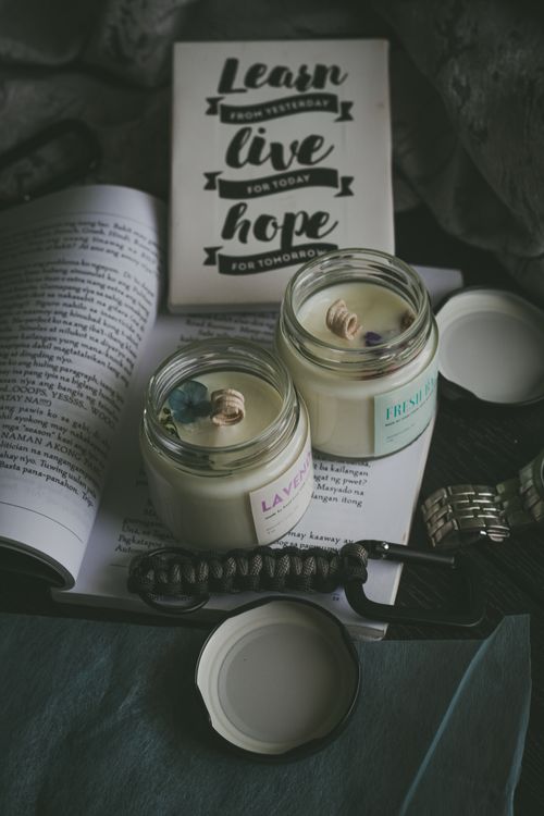 Free A cozy setup with lit candles and inspirational books for a relaxing reading atmosphere. Stock Photo
