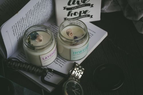 Free Close-up of lavender and fresh bamboo scented candles with books and watch setting the mood. Stock Photo
