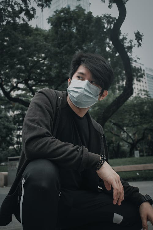 Free Young Man in Black Hoodie Wearing A White Face Mask  Stock Photo