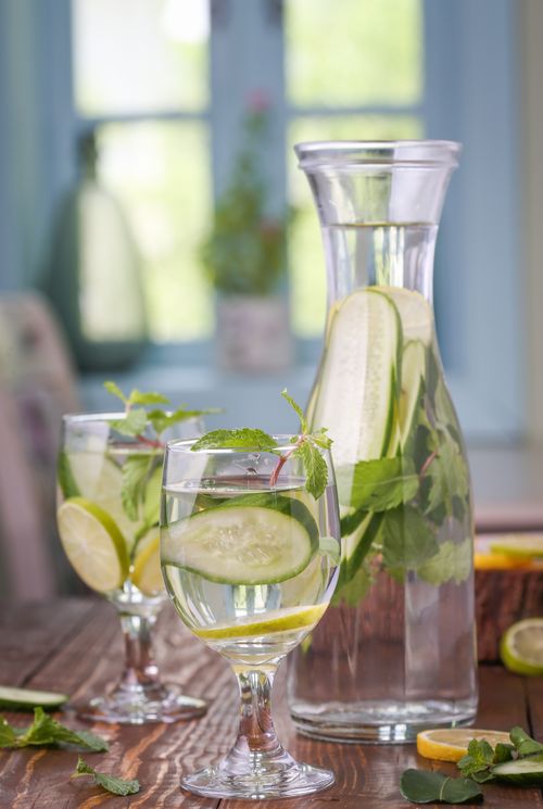 Free A refreshing detox drink with cucumber, lemon, and mint leaves in a glass pitcher and glasses. Stock Photo