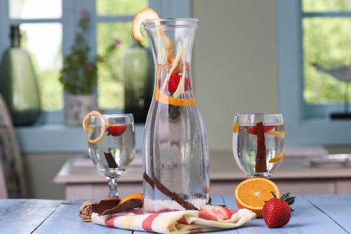 Detox Drink In Clear Glass Pitcher With Sliced Orange Fruit and Strawberry 