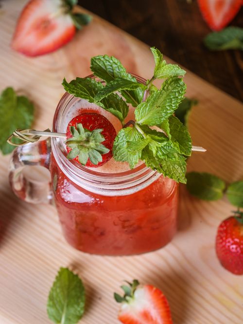 Free Top view of a strawberry mint drink in a jar, garnished with fresh mint leaves and sliced strawberries. Stock Photo