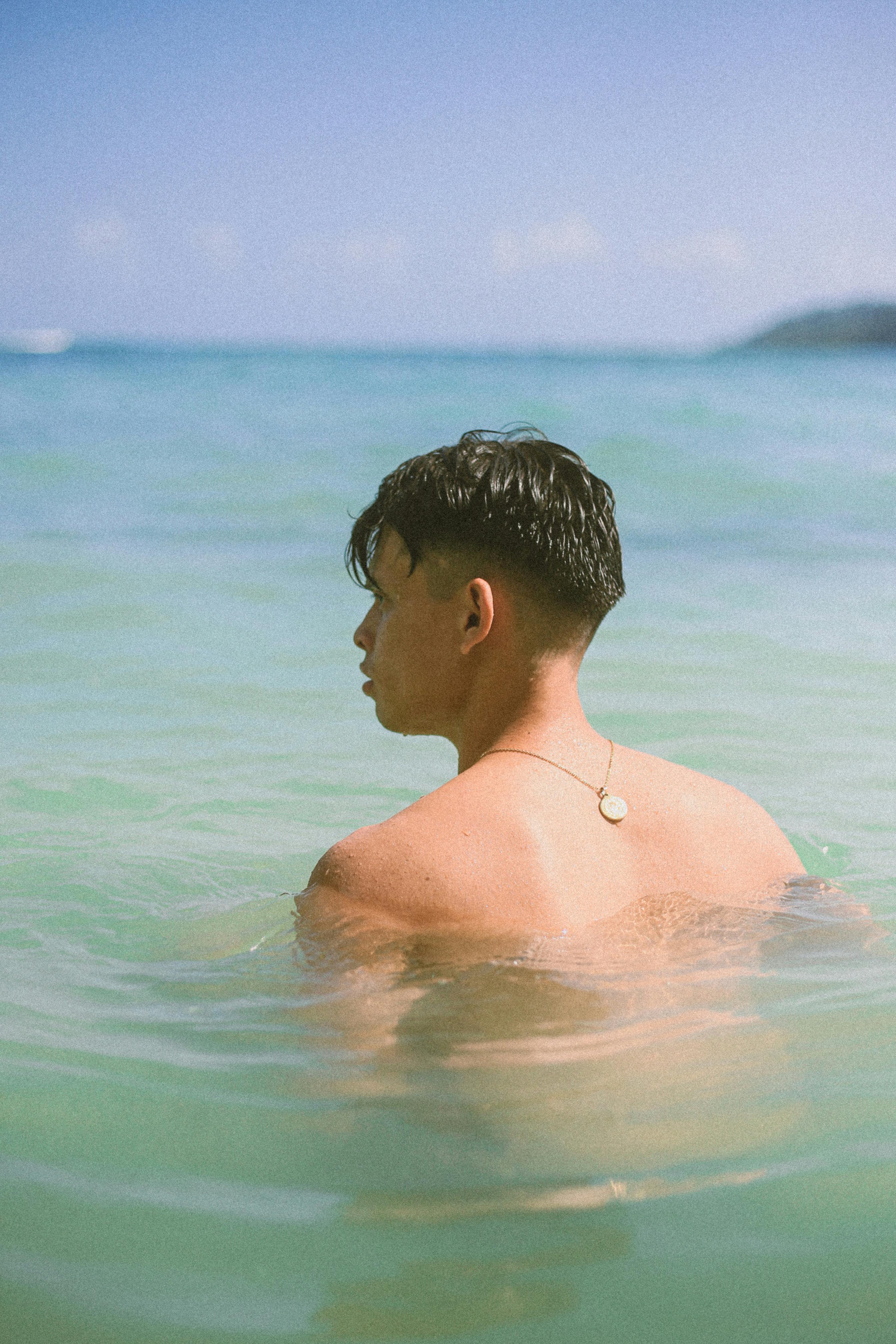 topless man in body of water