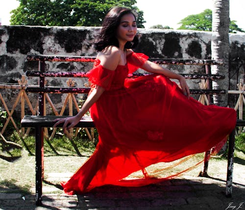 Foto profissional grátis de assento, menina sentada, vestido vermelho