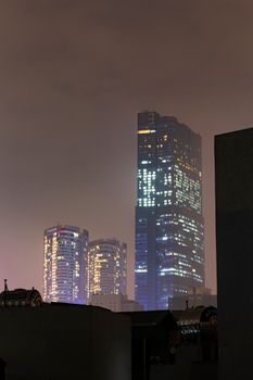 摩天大楼被迷人的夜间景观照亮，勾勒出戏剧性的城市轮廓