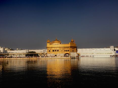 Stunning view of the Golden Temple in Amritsar, India, reflecting in the sacred pool at dusk.