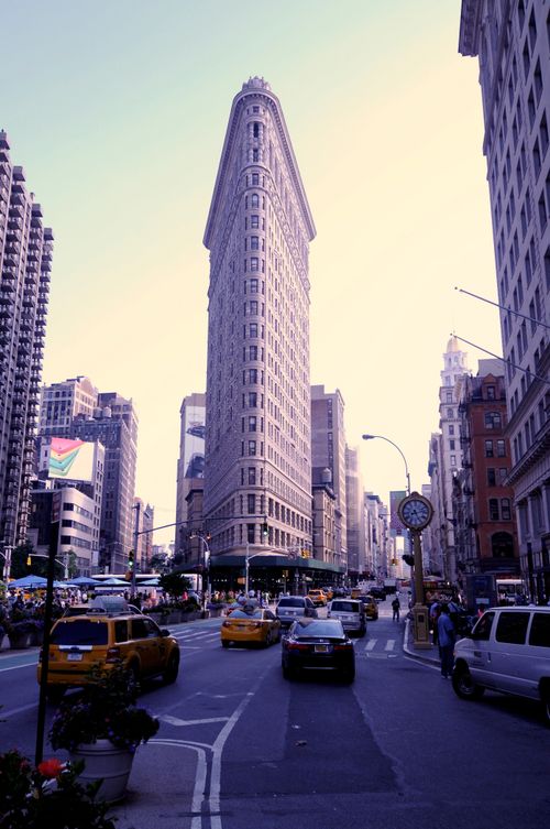 Free The iconic Flatiron Building in Manhattan, New York City, surrounded by bustling urban traffic and architecture. Stock Photo