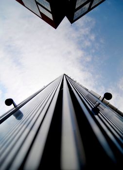 Low angle view of a modern skyscraper against a cloudy sky in New York City.