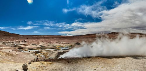 Free Breathtaking view of a steaming geyser in a vast desert landscape under a bright blue sky. Stock Photo