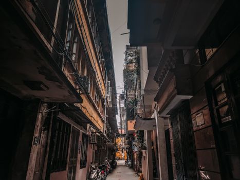 Explore a picturesque narrow alleyway in Hanoi, brimming with character and urban charm.